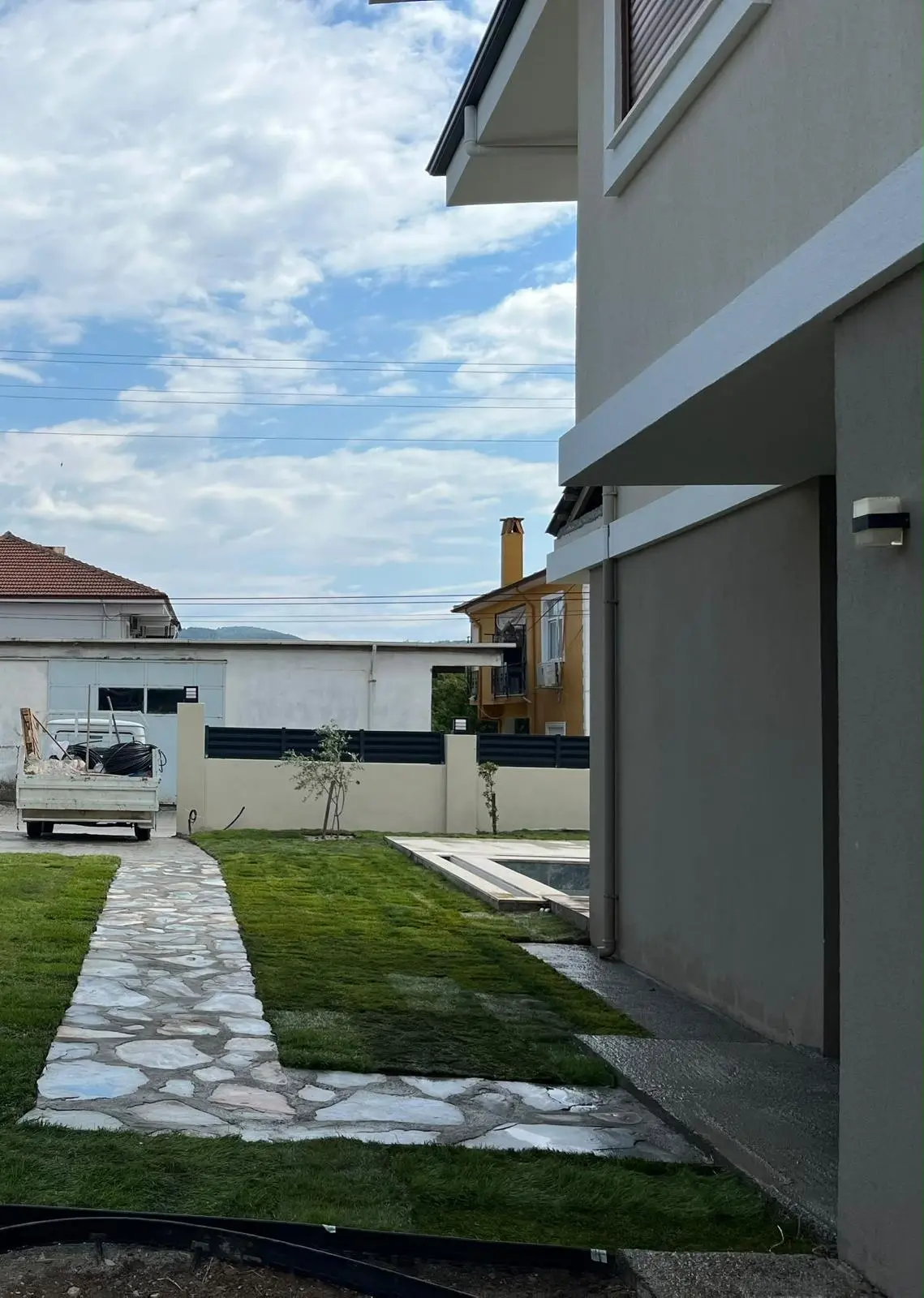 Bir evin yanındaki doğal taş döşeli dar bahçe yolu